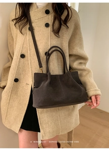 Detail of dark brown suede tote bag featuring retro texture and soft pleat design