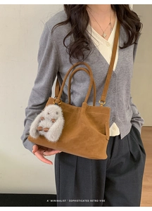 Brown textured tote bag detail featuring a plush rabbit charm and elegant retro vibes