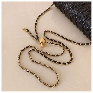 Détail de la boule dorée ajustable sur la bandoulière en cuir noir de ce sac chic