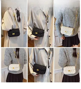 Détail du sac bandoulière matelassé en noir et beige avec bandoulière chaîne dorée