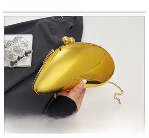 Detailed close-up of a gold mirrored evening clutch with metallic shell and chain strap