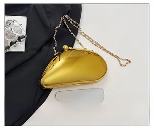 Golden bean-shaped acrylic evening clutch bag with chain strap shown next to a smartphone