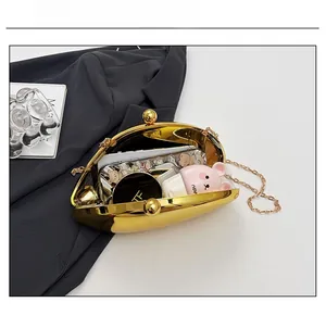Capacity view of golden shell acrylic clutch bag showing interior space and metal chain