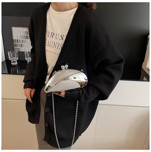 Silver mirror clutch bag with bead clasp and chain strap on a black sweater