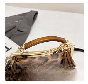 Détail du sac léopard avec poignée en résine et fermoir métallique doré brillant