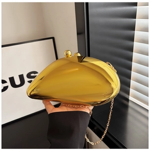 Detail of golden irregular acrylic evening bag with metallic mirror finish and chain