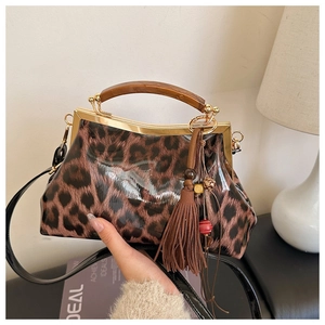 Détail du sac à main léopard avec poignée en bois, fermoir doré et accessoire à franges