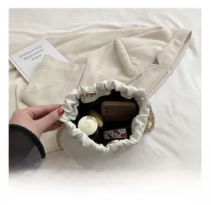 Interior view of white quilted bucket bag showing phone and cosmetics capacity