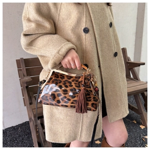 Détail du sac léopard avec fermoir en métal doré et franges décoratives en cuir marron