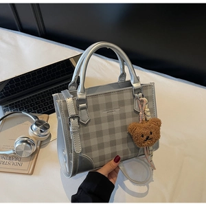Silver-grey checkered crossbody bag with fashion text and a brown plush bear charm