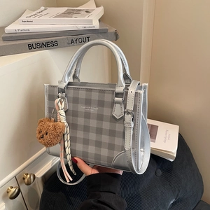 Silver checkered handbag with teddy bear charm and adjustable shoulder strap for women