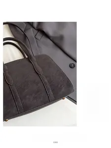 Detail of dark grey tote bag featuring reinforced stitching and protective metal feet