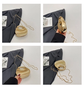Détail du sac de soirée doré avec texture à rayures verticales et poignée ronde en métal