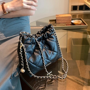 Quilted black leather bucket bag with gold chain strap and drawstring closure