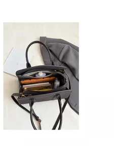 Detail view of the spacious inner compartments and side zipper pocket of the leather handbag
