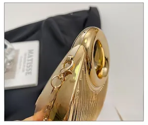 Détail du sac de soirée doré avec chaîne en métal et design à texture rainurée chic