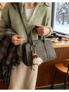 Detail of dark grey vintage faux suede crossbody bag with cute puppy plush charm