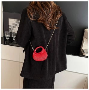 Vue détaillée du mini sac rouge avec rayures verticales et bandoulière chaîne dorée