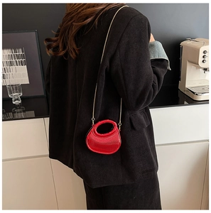 Détail du mini sac rouge en cuir texturé avec bandoulière chaîne dorée et poignée