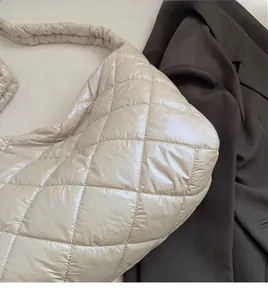 Close-up of cream quilted puffer handbag showing soft material and rhombus pattern texture