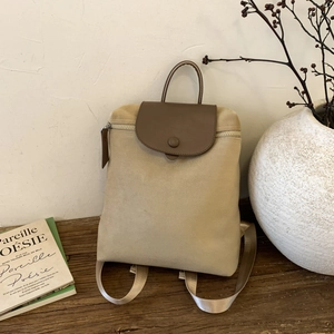 Minimalist beige canvas backpack with brown leather flap for women, retro stylish design