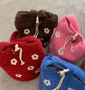 Variety of knitted floral shoulder bags in red, brown, pink, and blue with horn buttons