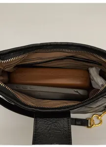 Internal view of black pleated crossbody bag with brown striped lining and heart buckle