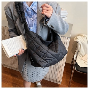 Detailed view of the large quilted tote bag featuring a padded texture and side drawstrings