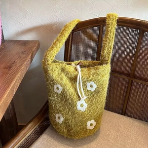 Ginger yellow plush bucket bag with white floral embroidery and drawstring closure