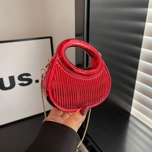 Sac à main demi-lune rouge poli avec rayures verticales et bandoulière chaîne dorée