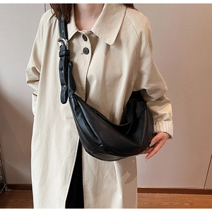 Minimalist black crescent hobo bag with pebbled leather texture and silver buckle strap