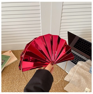 Detail of fan-shaped metallic red clutch with gold chain strap and pleated hard shell