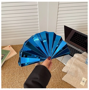 Detail of fan-shaped evening clutch in metallic blue with gold circular handle
