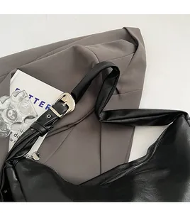 Close-up of wide comfortable leather shoulder strap and silver buckle on black hobo bag