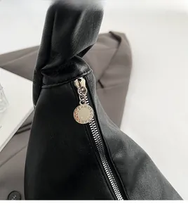 Detail of lychee pattern black leather bag with premium silver zipper and KCLEAR charm