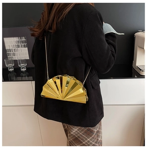 Detailed view of fan-shaped golden evening clutch bag with sequins and thin chain strap