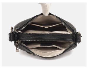 Detail view of the black leather bag interior with three separate zipper compartments