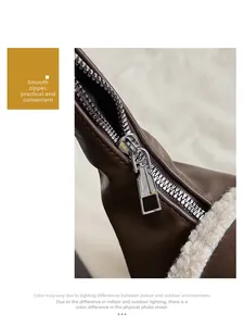 Détail d'un sac en cuir marron montrant la fermeture éclair argentée et le bord en fourrure