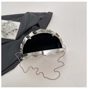 Close-up of semi-circle silver evening clutch with metallic finish and black lining detail