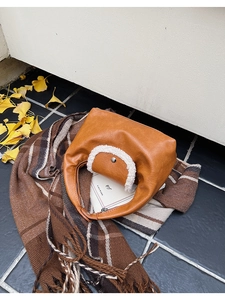 Détail d'un sac en cuir PU marron avec bordure en laine de mouton blanche et bouton