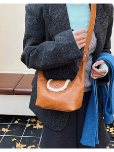 Détail du sac bandoulière en similicuir marron avec bordure en polaire blanche et boucle