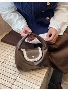 Détail de la couture contrastée en similicuir et bordure en peluche blanche du sac