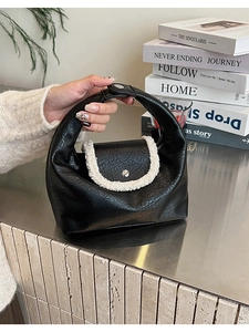 Détail du sac demi-lune noir en similicuir avec bordure en peau de mouton blanche et boucle