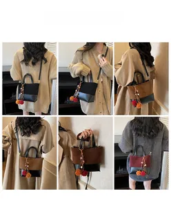 Detail view of contrast color shoulder bags featuring fuzzy pom-poms and leather textures