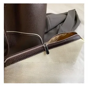 Close-up of premium silver zipper and leather trim on minimalist canvas tote bag