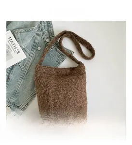 Top view of a brown plush bucket bag styled with a denim jacket and art print