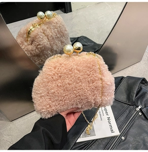 Detail of pink faux fur crossbody bag with large pearl clasp and golden chain strap