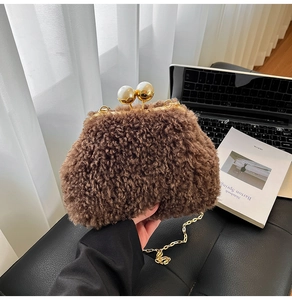 Detailed view of brown plush bag with gold chain strap and large pearl closure