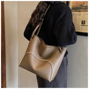Detail of lychee pattern leather tote bag with unique white wavy edge piping design
