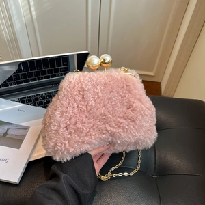 Detail of pink faux fur crossbody bag with large pearl clasp and gold chain strap
